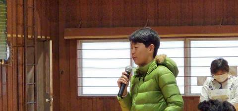 緑のダウンを着てマイクで話す男子生徒